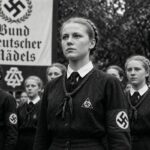 Czarno-biała ilustracja: członkinie Bund Deutscher Mädel w szeregu przed sztandarem związku