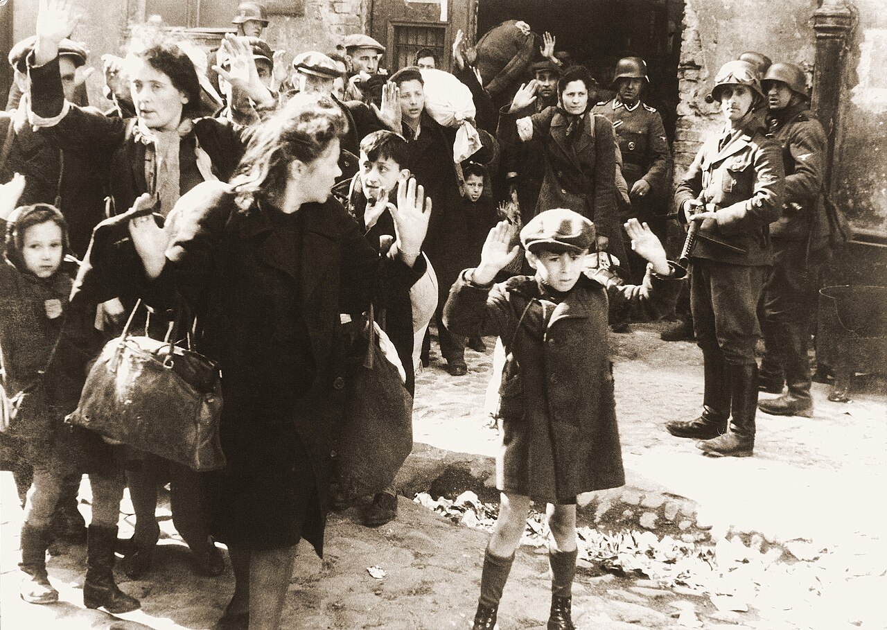 Zdjęcie z raportu Jürgena Stroopa: Żydzi wyprowadzani siłą z bunkrów w getcie warszawskim, 1943