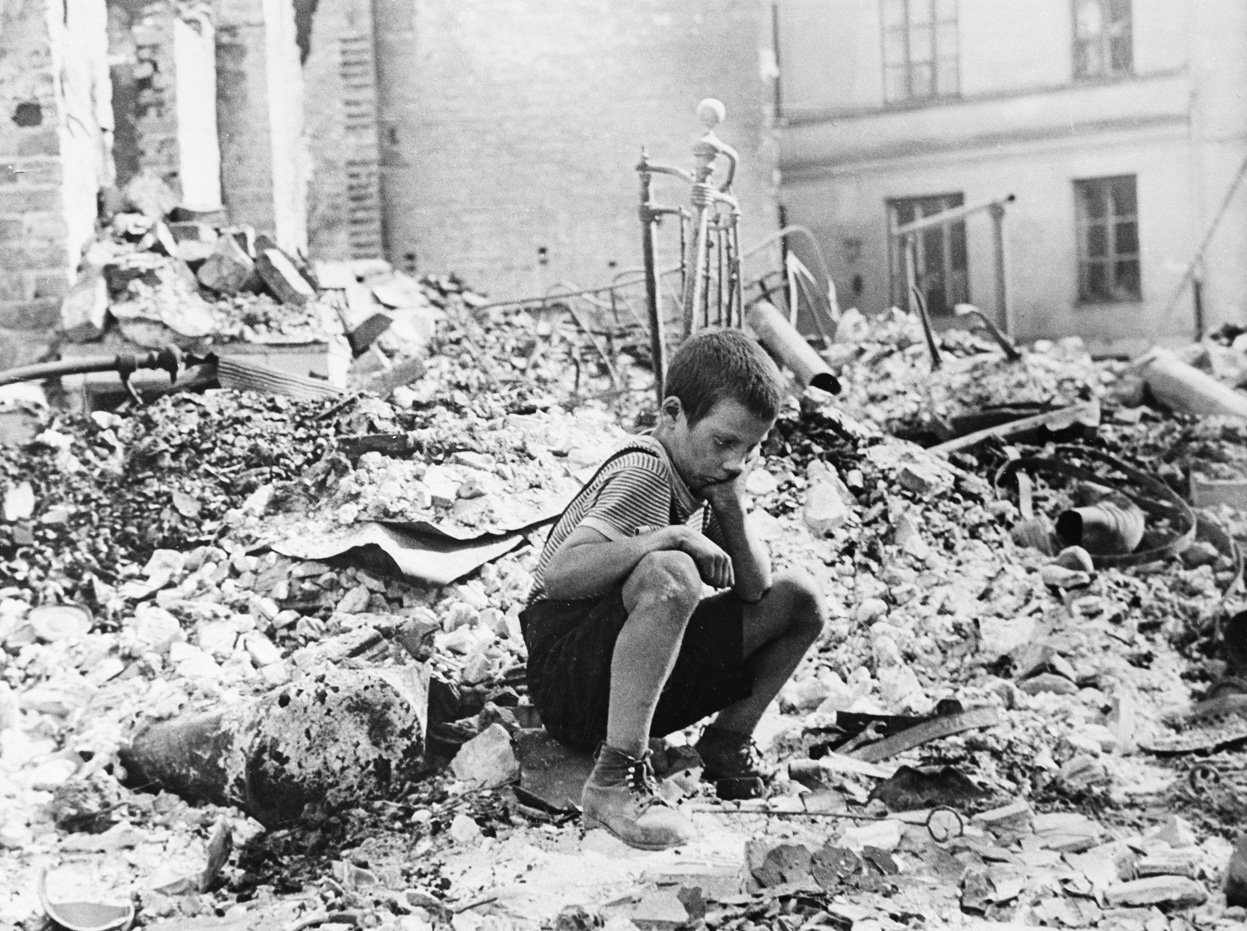 Chłopiec na gruzach zbombardowanej kamienicy w oblężonej Warszawie, wrzesień 1939